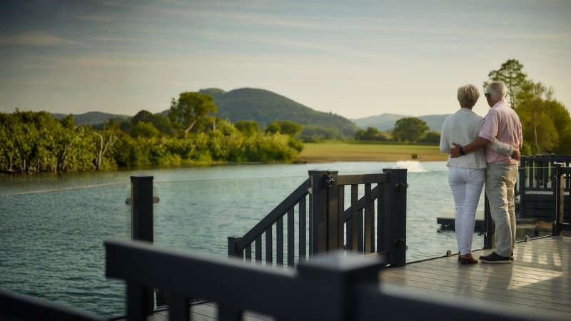 Holiday home owners enjoying the peaceful coastal views from their caravan decking at Green Meadow.